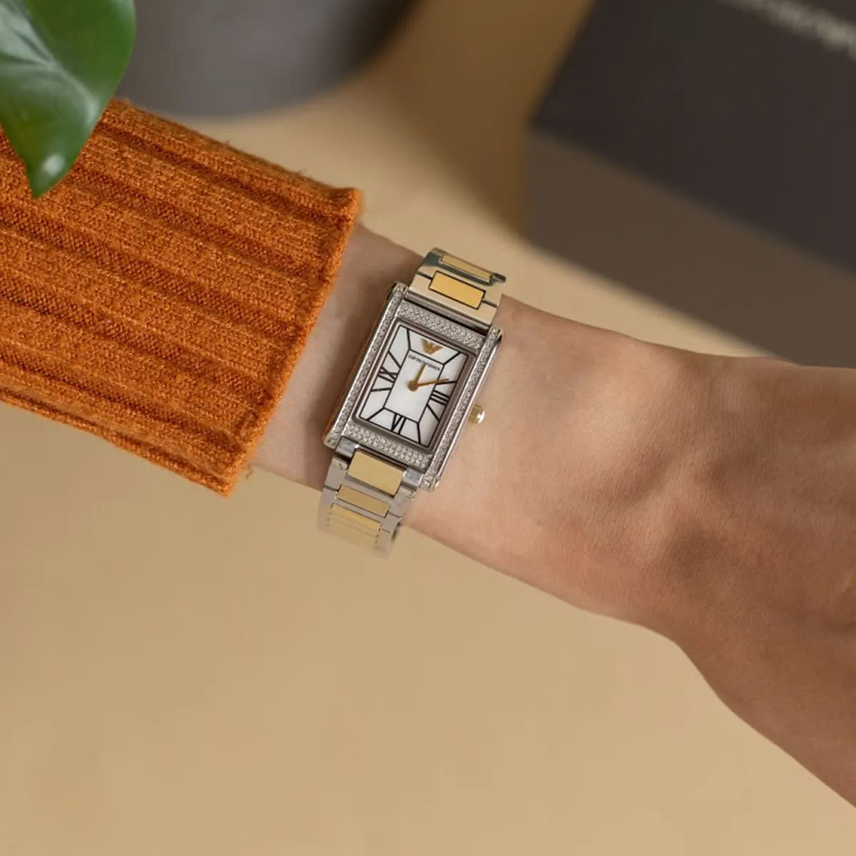 Emporio Armani Genni watch worn on wrist with two-tone bracelet and white dial