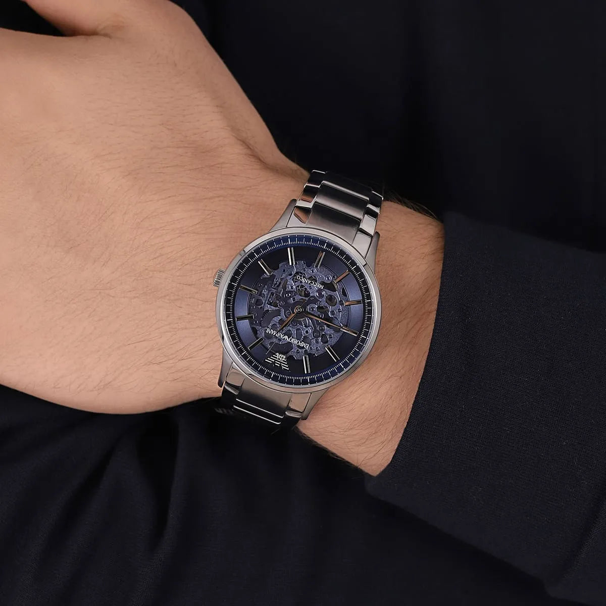 Emporio Armani Renato skeleton watch on wrist showing silver bracelet and blue dial