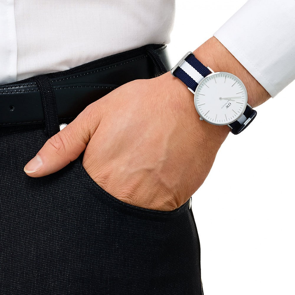 Daniel Wellington Glasgow silver watch on wrist showing white dial and navy striped strap detail