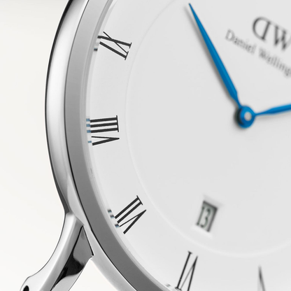 Close-up of Dapper Durham dial detail showing Roman numerals, blue hands, and date window