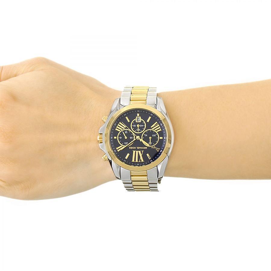 Michael Kors Bradshaw chronograph watch on wrist, displaying blue dial and two-tone bracelet