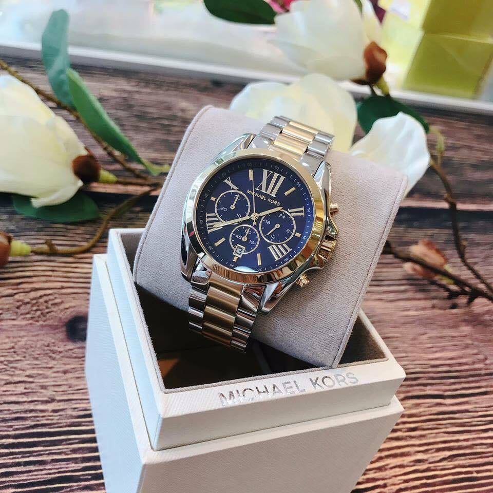 Michael Kors Bradshaw chronograph watch displayed in branded white gift box with flowers