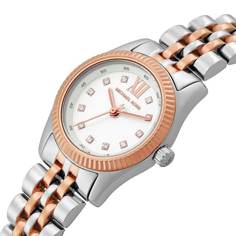 Angled view of Michael Kors Lexington watch displaying white dial with rose gold accents and two-tone steel bracelet