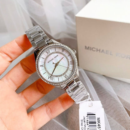 Michael Kors Lauryn watch held in hand showing crystal bezel detail