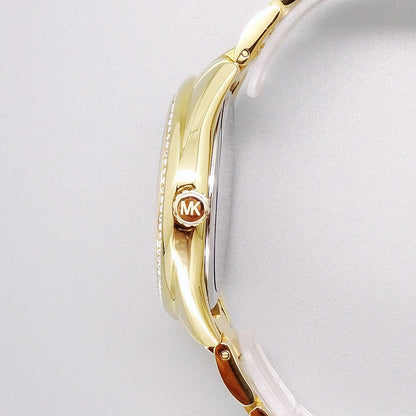 Side view of Michael Kors MK7090 watch showing gold-tone case with crystal bezel and metal strap