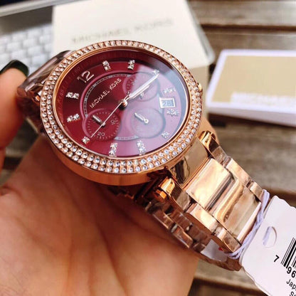 Close-up of red dial with chronograph subdials, diamond hour markers, and Michael Kors branding
