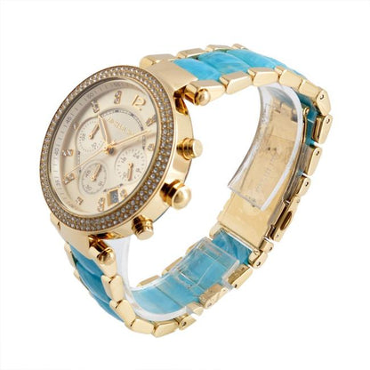 Michael Kors Parker watch angled view showing gold-tone case, blue strap, and chronograph subdials