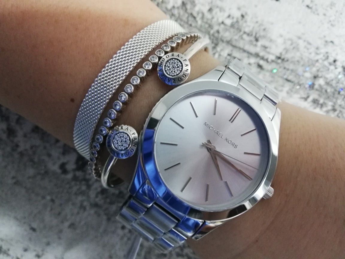 Michael Kors Runway silver watch on wrist styled with bracelets