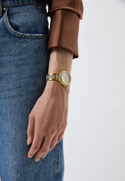 Michael Kors Taryn gold-tone watch worn on wrist with mother-of-pearl dial