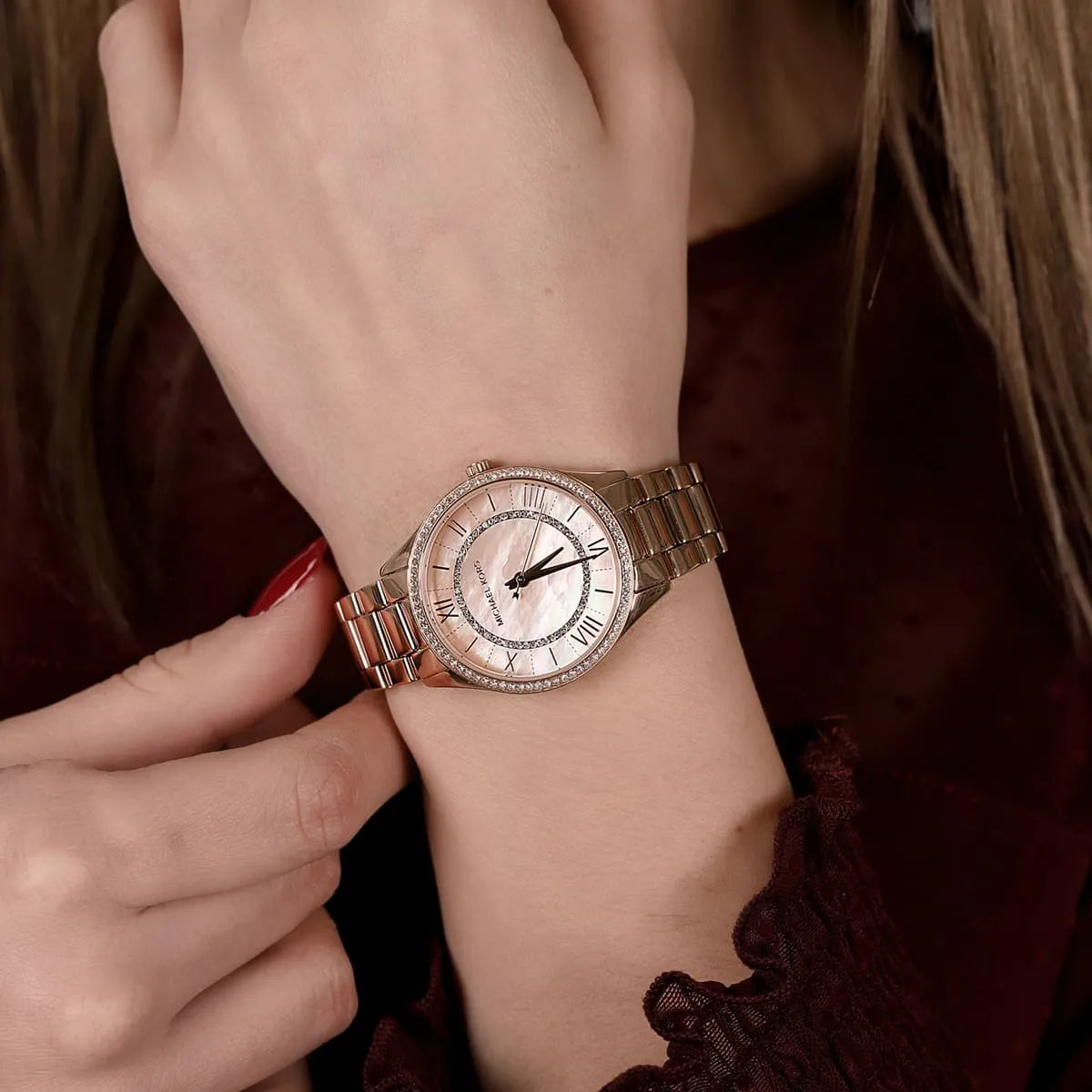 Michael Kors Lauryn rose gold women's watch worn on wrist with crystal bezel detail