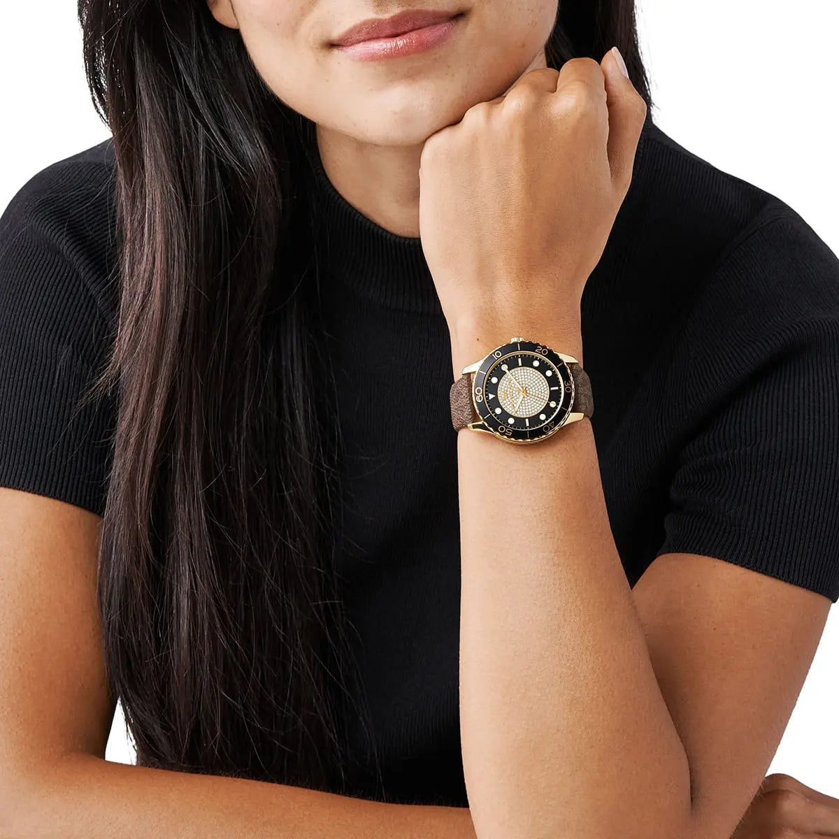 Michael Kors Runway Dive watch worn on wrist with gold case and black bezel