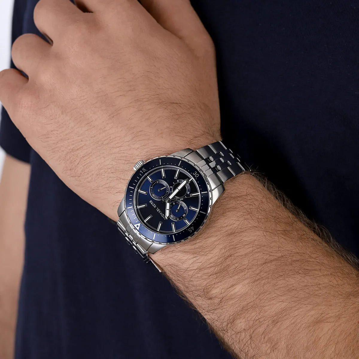 Michael Kors Cunningham multifunction watch worn on wrist with blue dial and silver metal bracelet