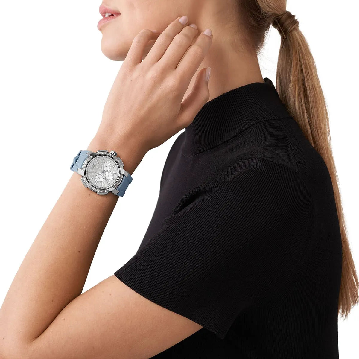 Michael Kors Sidney watch worn on wrist, oversized silver case with white dial and blue strap