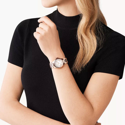 Michael Kors Mini Camille rose gold watch worn on wrist over black outfit