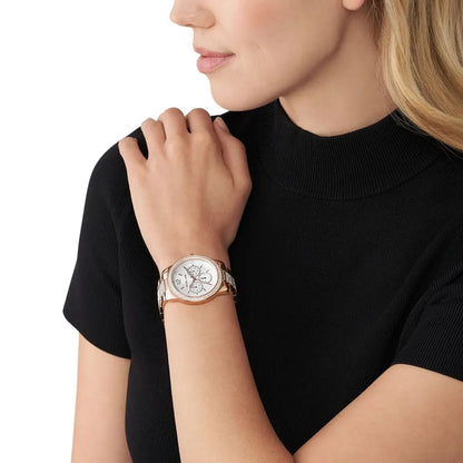 Michael Kors Oversized Tibby rose gold women's watch worn on wrist with silver chronograph dial
