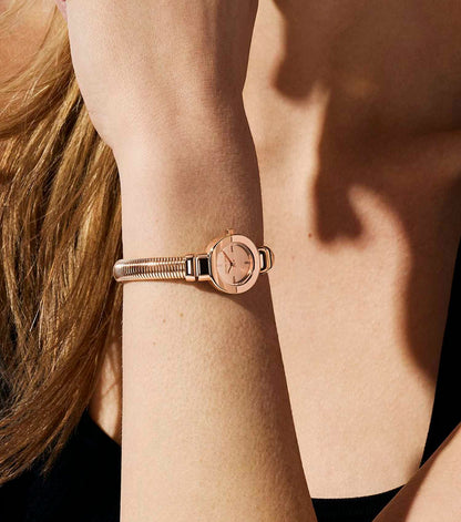 Michael Kors Mini Gramercy rose gold watch worn on wrist with textured bangle bracelet