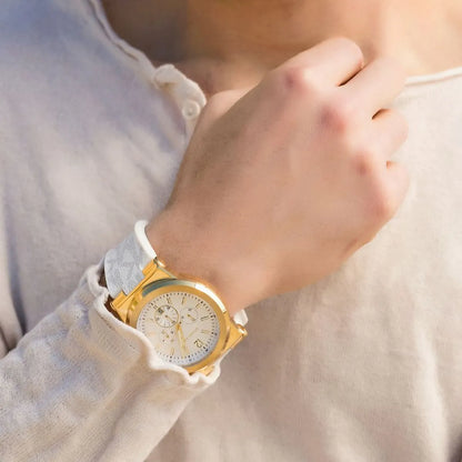 Michael Kors Dylan chronograph watch worn on wrist with white strap and gold-tone case