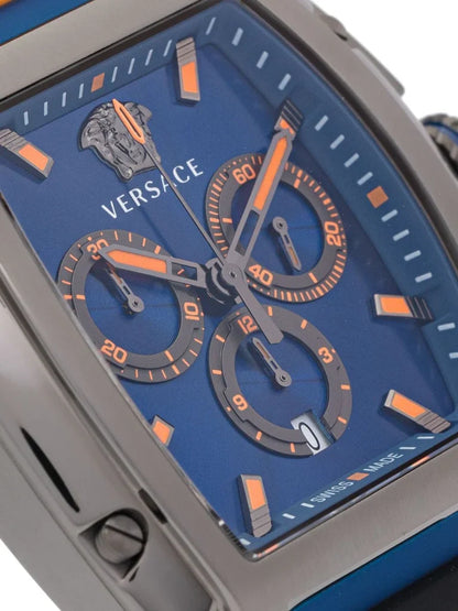 Close-up of Versace Dominus blue dial with orange chronograph subdials, hour markers, and Versace logo