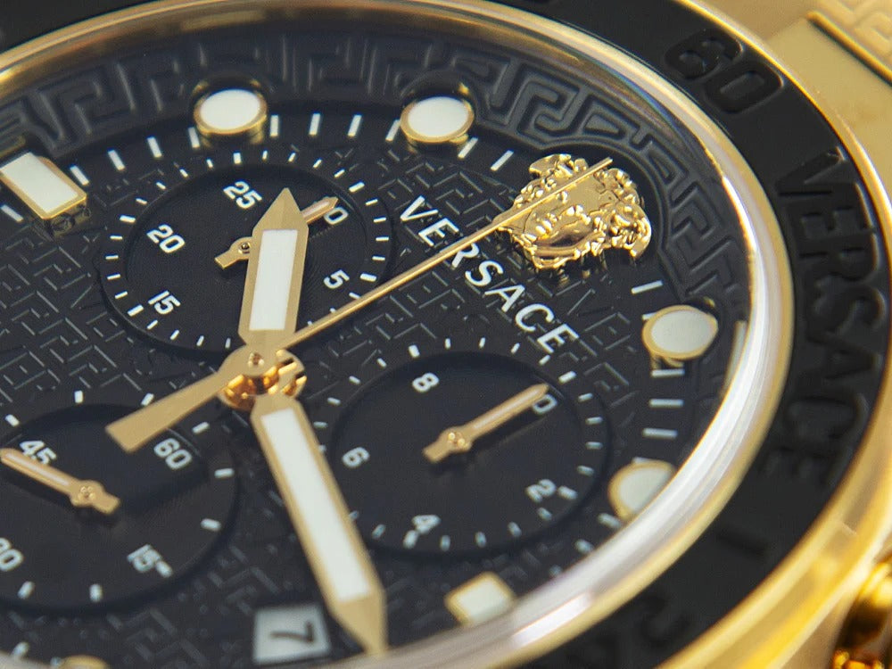 Close-up of Versace Greca Dome black dial with gold chronograph hands, Medusa logo, and hour markers