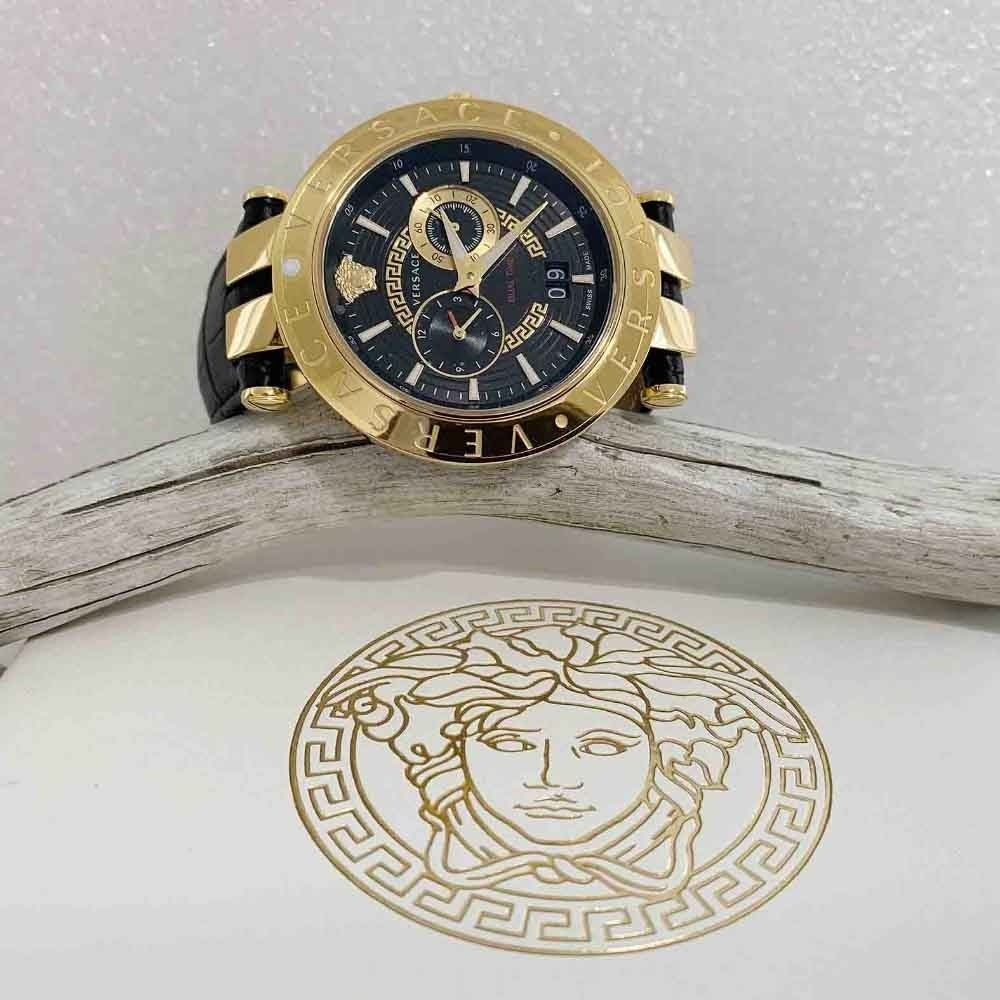 Versace V-Race watch on angled stand showing gold case, black dial, and Medusa logo detail